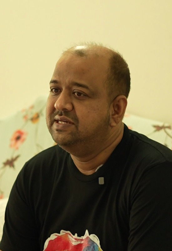 Prof. Abu Muhammad Abdullah speaking at home, a pack of Chumuk on the table