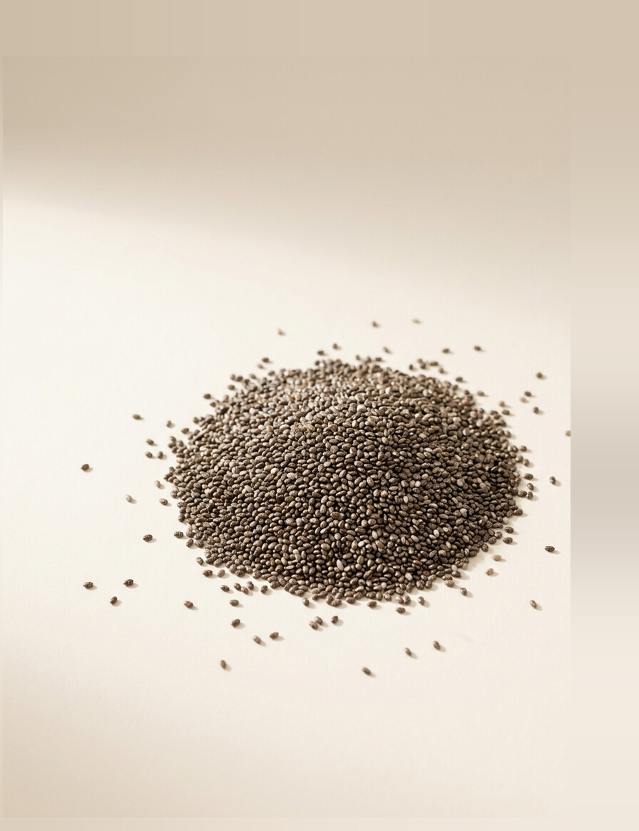 A scattered mound of small mottled grey-brown chia seeds.