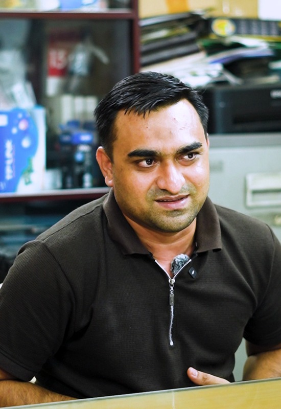 Raju Hossain speaking at his desk in an office